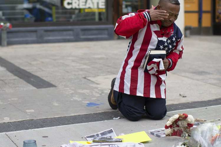 Un uomo piange davanti al memoriale di Boston