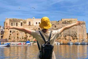 Viaggiatrice e castello sul mare