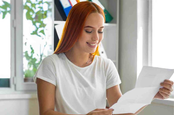 Donna sorridente legge lettera