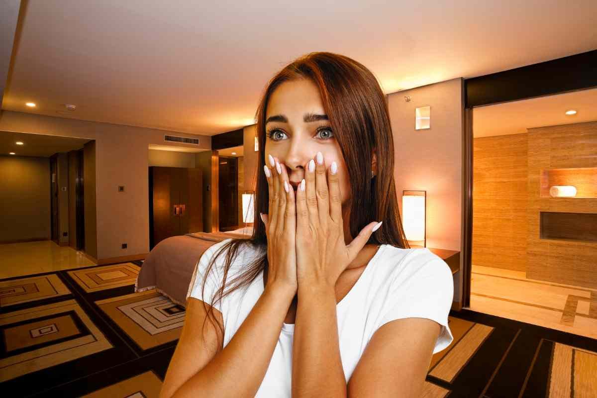 Donna con mani sul volto e stanza hotel