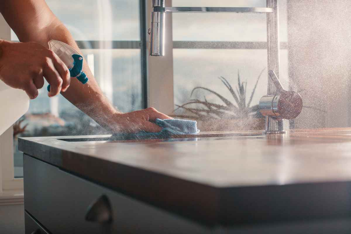 Persona che pulisce il bancone di una cucina