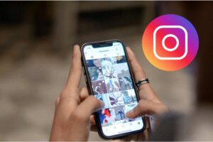 smartphone tra le mani e logo instagram