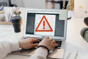 uomo scrive mail, segnale pericolo
