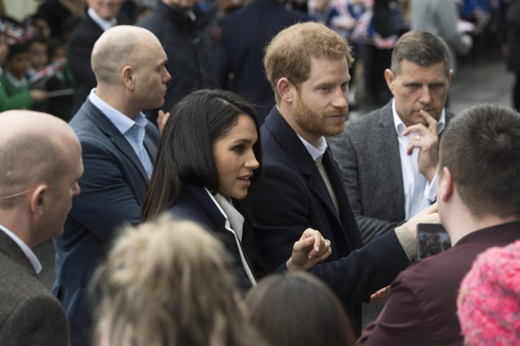 Meghan e Harry circondati dalla folla insieme alle guardie del corpo