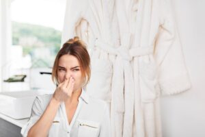 accappatoio e donna che si tappa il naso