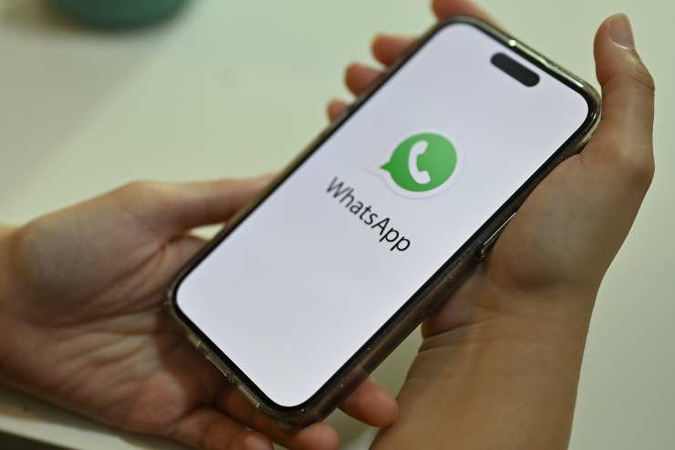 cellulare in mano con icona whatsapp