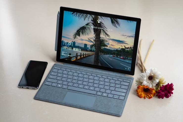 Computer Windows con uno smartphone e dei fiori
