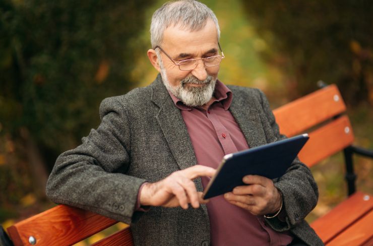 Pensionato che guarda il tablet