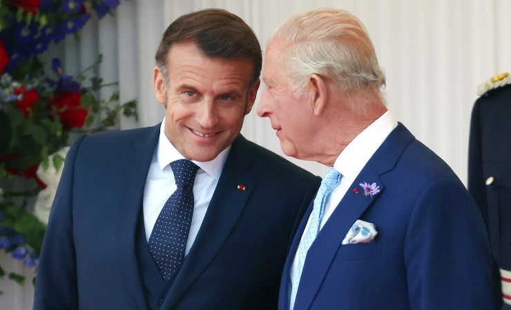 Macron sorride e Carlo III lo ascolta