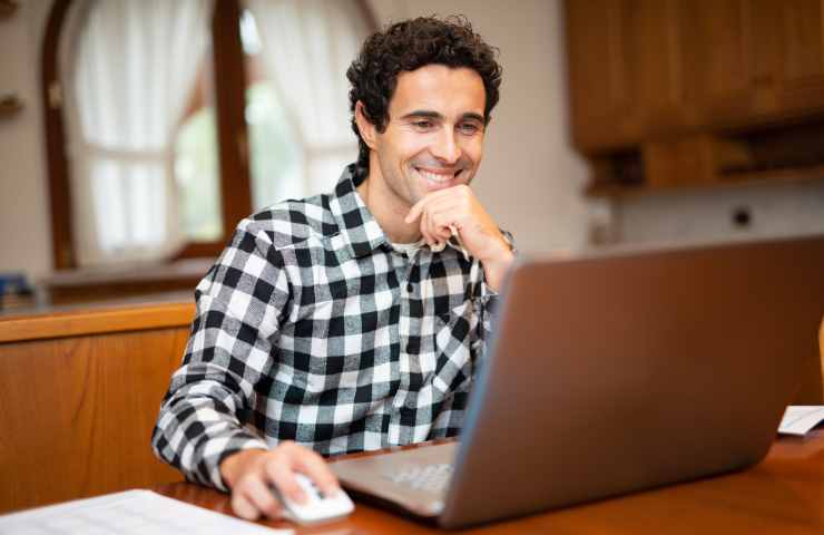 uomo sorridente al pc