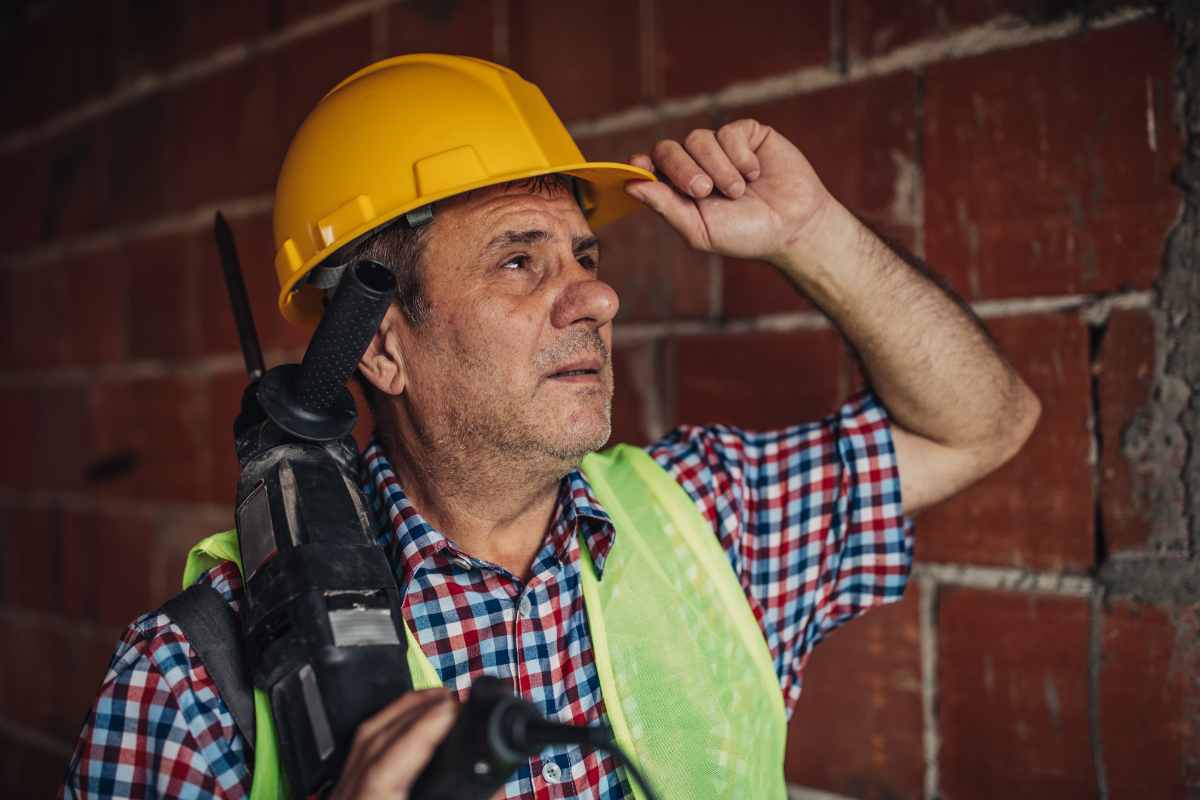 operaio affaticato con trapano in mano