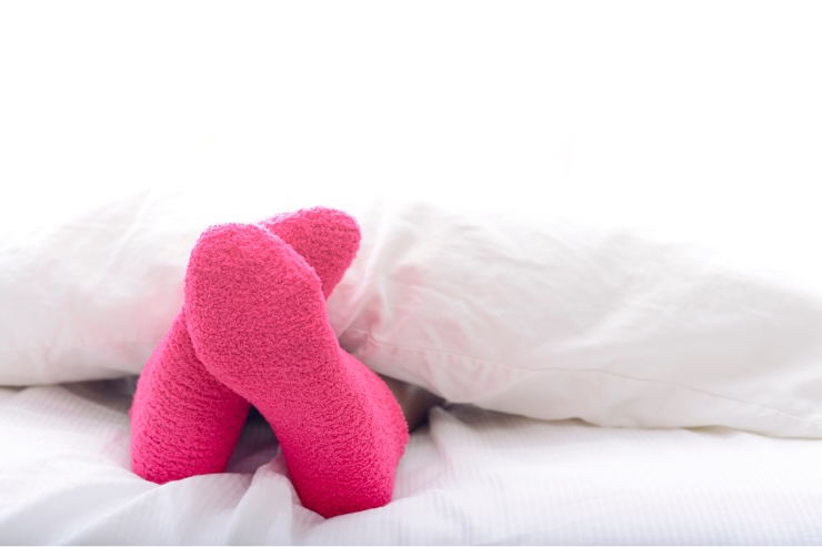 piedi nel letto con calzini rosa