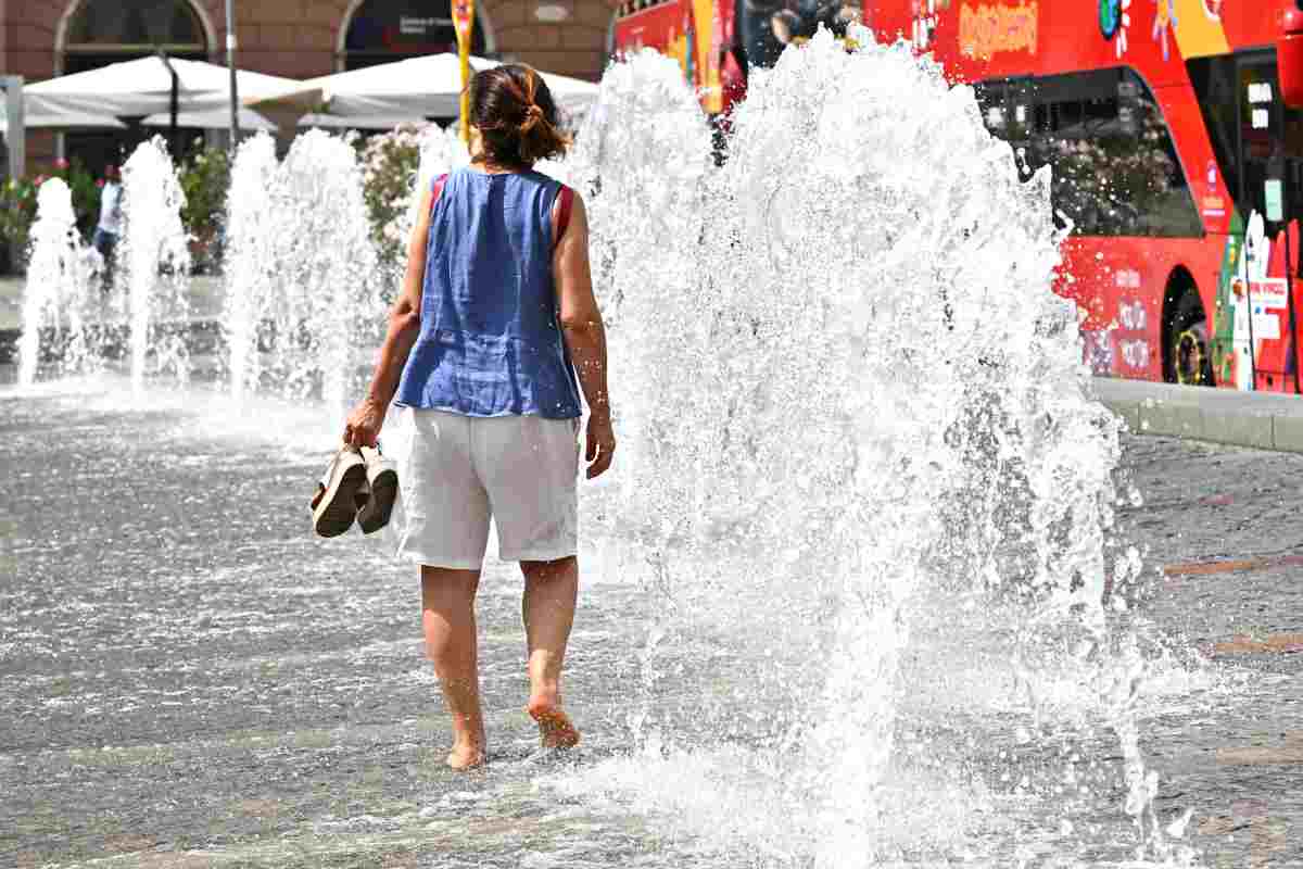 una persona si rinfresca a una fontana