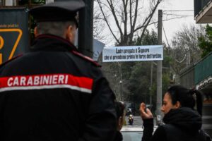 Carabiniere di spalle, sullo sfondo un cartello per i ladri