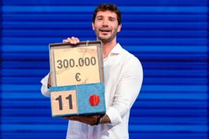 Stefano De Martino mostra in primo piano il pacco da 300.000€