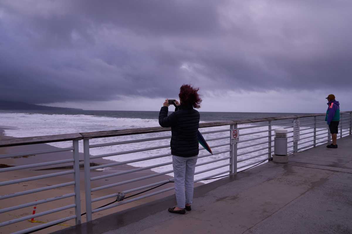 Una donna scatta una foto al cielo nuvoloso