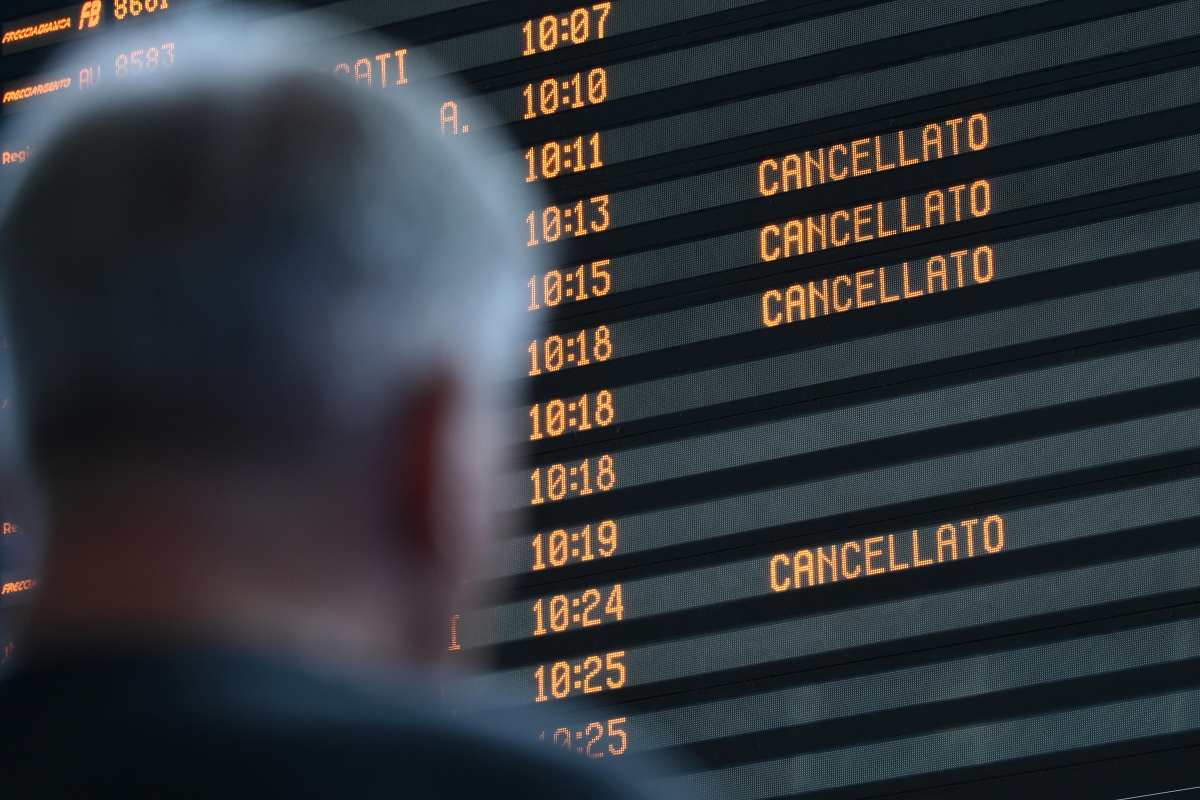 Uomo che guarda il monitor in una stazione ferroviaria