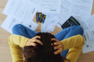 ragazza si mette le mani in testa mentre fa i conti