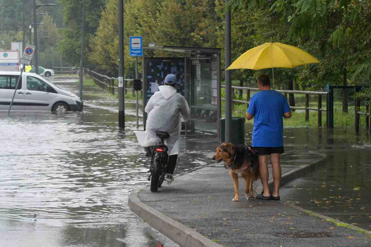 una persona si ripara dalla pioggia con l'ombrello