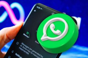 Logo WhatsApp in primo piano su uno smartphone tenuto in mano