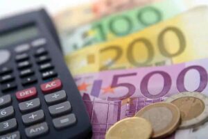 soldi con vicino una calcolatrice