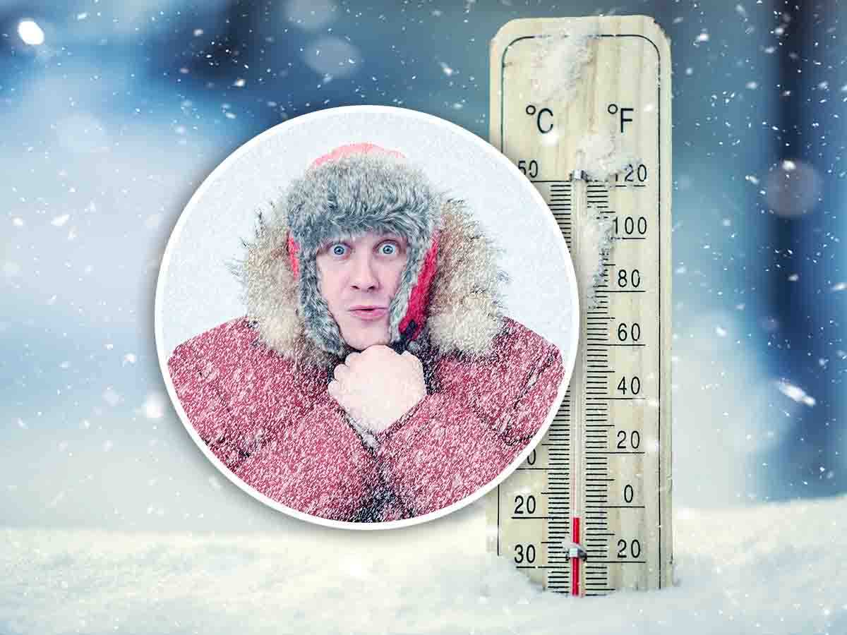 uomo con il cappotto con dietro un termometro