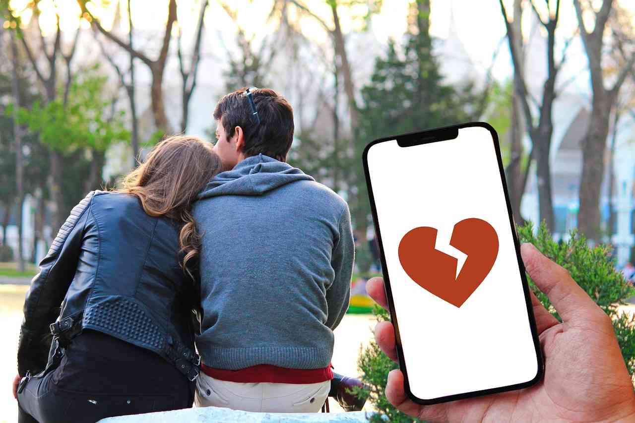 immagino smartphone con cuore spezzato e vicino una coppia